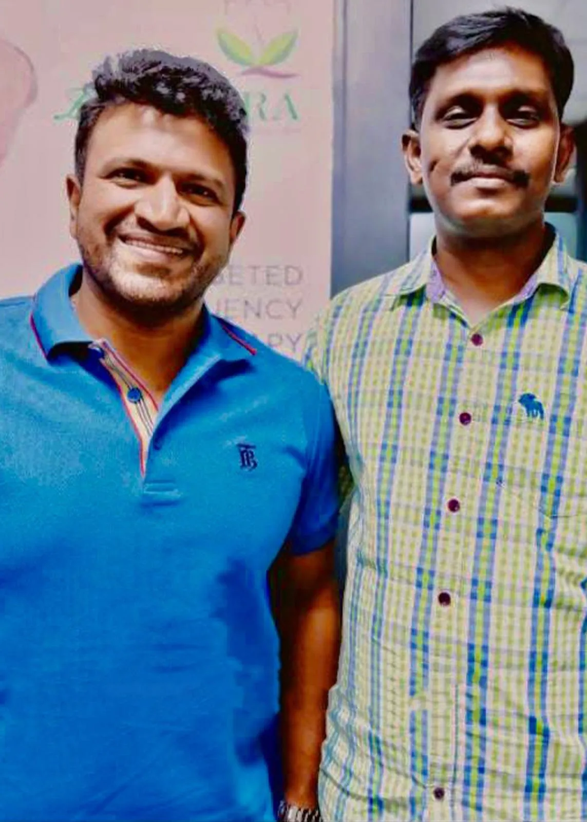 Two men standing side by side in front of a Le Yantra banner inside the clinic.