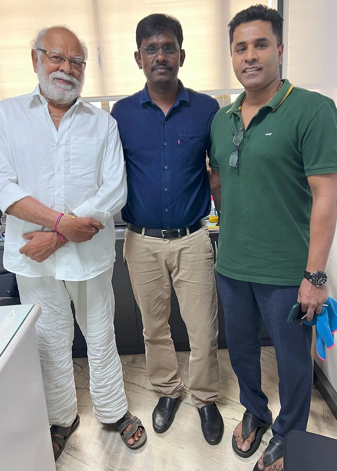 Three men standing side by side in an office at the clinic.
